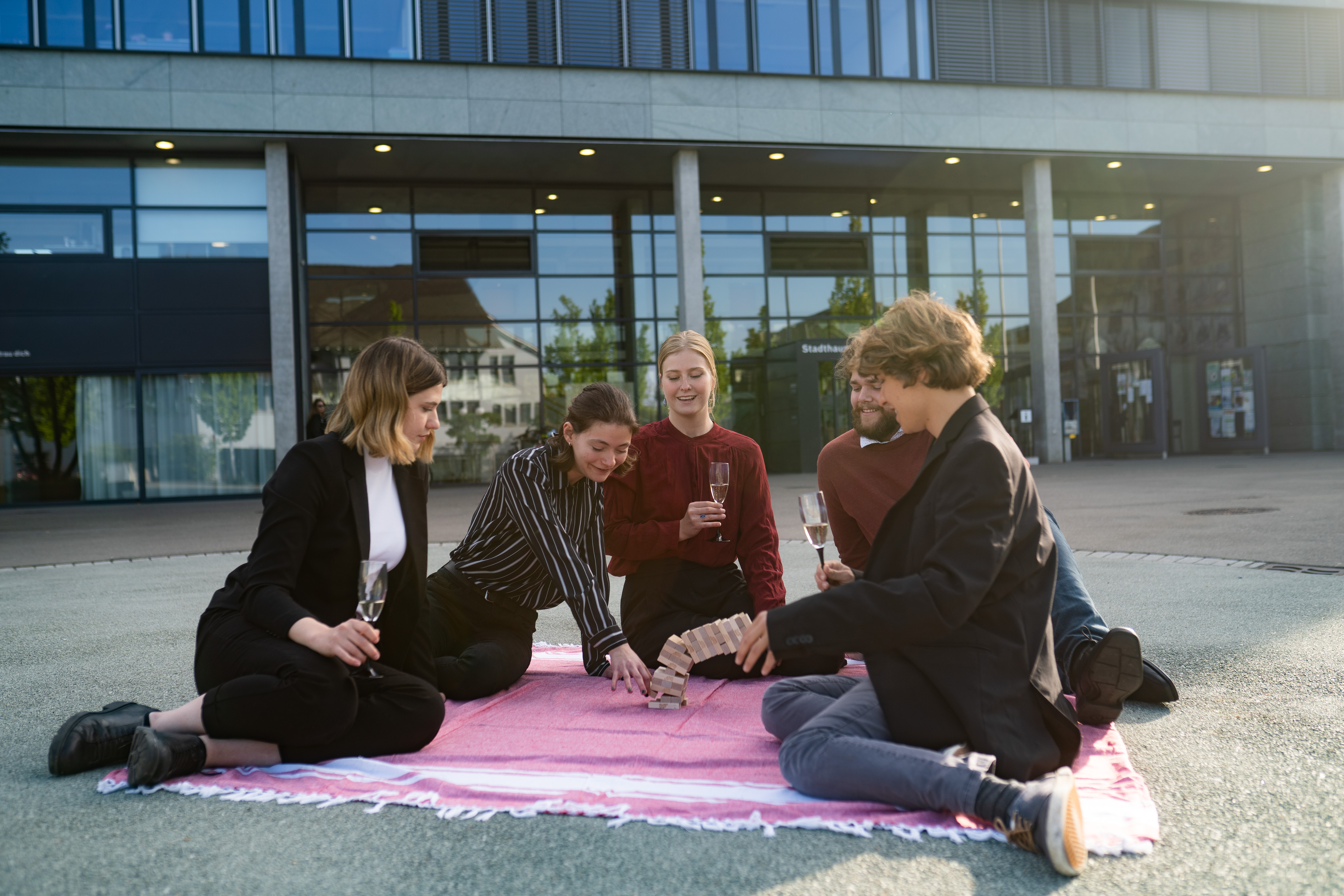 Fünf Aktivist*innen spielen Jenga vor dem Dübendorfer Stadtparlament. Das Spiel symbolisiert, was die Jungsozialist*innen von der Schuldenbremse halten.